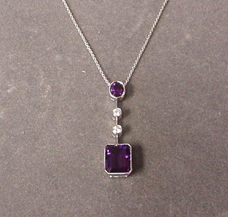 A lady's white gold pendant set a rectangular cut amethyst and 2 diamonds, surmounted by an oval cut amethyst
