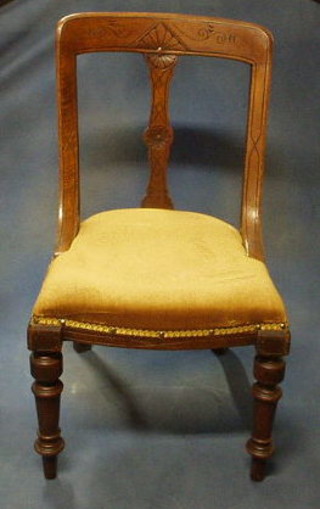 A pair of Victorian carved oak bar back dining chairs with carved splat and upholstered seat on turned supports