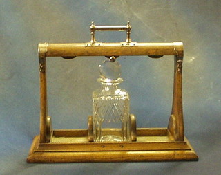 An oak and silver plated tantalus frame fitted a cut glass decanter and stopper