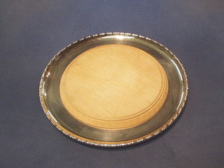 A circular silver plated bread board holder 10"