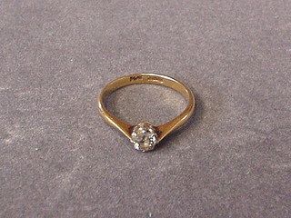 A lady's solitaire diamond engagement ring set on a gold shank