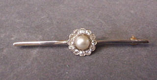 A lady's "gold" bar brooch set a simulated pearl and numerous white stones