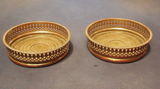 A pair of circular pierced silver plated wine coasters