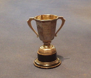 A miniature silver twin handled trophy cup