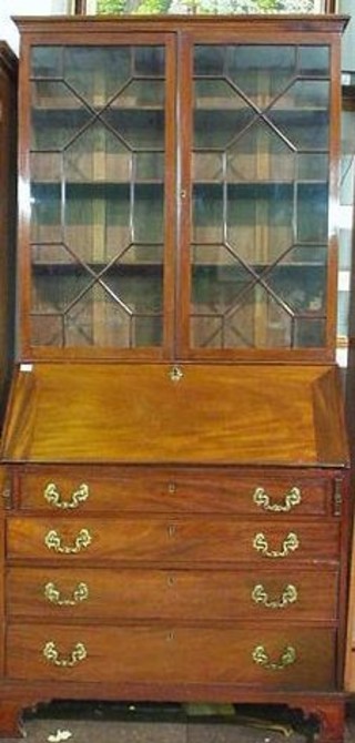 A Georgian mahogany bureau bookcase with associated later top fitted shelves enclosed by astragal glazed panelled doors, the base fitted a fall front revealing a well fitted stepped interior above 4 long drawers, raised on bracket feet 40"