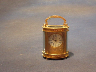 A 19th Century 8 day miniature carriage clock with porcelain dial and Roman numerals contained in an oval gilt metal case by Elliott & Sons of London, 3"