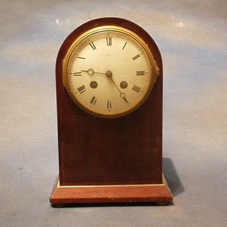 An Edwardian 8 day striking mantel clock with porcelain dial and Roman numerals contained in an arched inlaid mahogany case