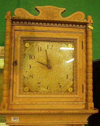 A 30 hour striking longcase clock, the 10" square painted with spandrels painted flowers and Arabic numerals, contained in a stripped pine case 83"