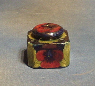 A Moorcroft Pansy pattern (dark blue ground) inkwell and cover fitted 4 pen recepticals and having a 1 1/2" chip to the lid, the base marked Moorcroft England
