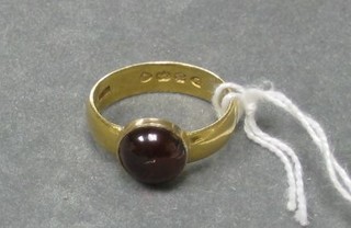 A 22ct gold band set a cabouchon cut red stone