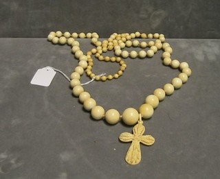 A string of ivory beads hung an ivory cross in the form of ears of corn