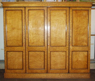 A fine quality Victorian Birds Eye maple triple wardrobe with moulded cornice and enclosed by 4 panelled doors, raised on a platform base 88"