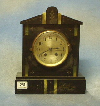 A striking 8 day mantel clock with silvered dial contained in a black marble architectural case
