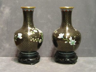 A pair of 20th Century black ground cloisonne shaped baluster vases on stands 9"