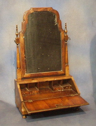 A "Queen Anne" arched plate dressing table mirror raised on a miniature bureau, the fall front revealing a fitted interior above 1 long drawer, on bun feet 19"