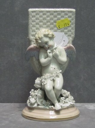 A 19th Century Continental porcelain spill vase in the form of a basket supported by a winged cherub 8"