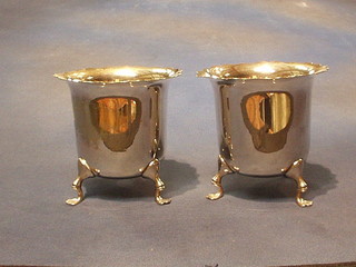 A pair of circular silver plated vases with wavy cut borders, raised on hoof supports 5"