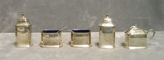 A silver 5 piece condiment set comprising:  mustard pot, 2 salts and 2 peppers with blue glass liners, Birmingham 1933, 6 ozs