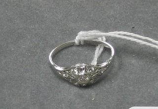 An 18ct white gold dress ring set an oval cut diamond supported by 2 baguette cut diamonds and numerous smaller diamonds