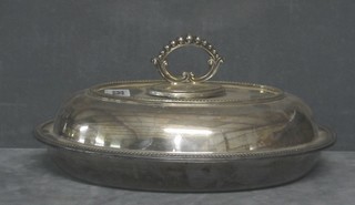 An oval silver plated entree dish and cover with bead work border