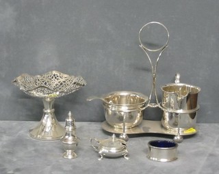 A circular silver plated cream jug with matching sugar bowl contained in a cruet frame, a pierced plated tazza and a 3 piece silver plated condiment set