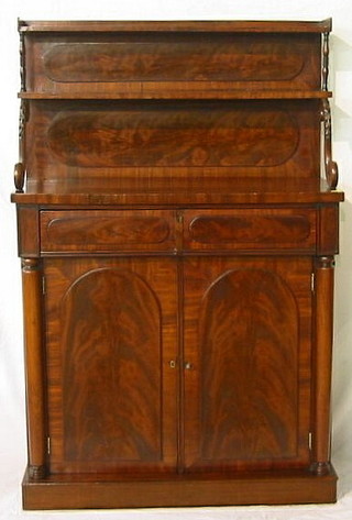 A Regency mahogany sideboard the raised back fitted a shelf and with column and scrolled supports, the base fitted 1 long drawer above a double cupboard enclosed by arch shaped panelled doors, flanked by a pair of columns 34"