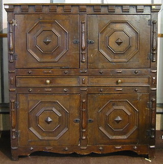 A Continental 18th Century oak cabinet with moulded and dentil cornice, the upper section enclosed by panelled doors, the base fitted 2 drawers above a double cupboard, raised on square tapering supports 56"