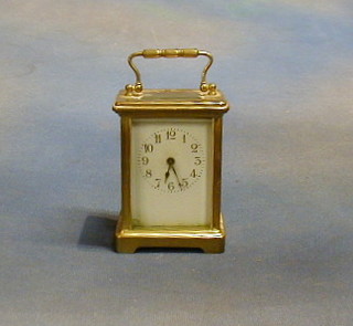 A 19th Century carriage timepiece with Roman numerals and enamelled dial contained in a gilt metal case