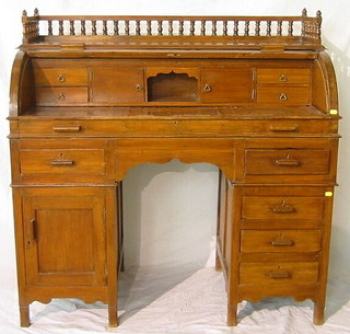 A 19th Century colonial hardwood cylinder bureau, the top with bobbin turned three-quarter gallery, the cylinder revealing a well fitted interior above 8 drawers, raised on square supports 47"