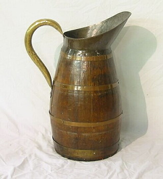 A circular coopered jug with brass spout and handle 22"