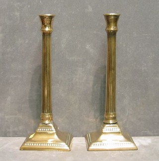 A pair of brass reeded candlesticks on square bases 11"