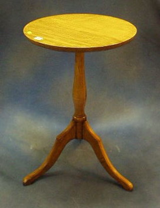 A 19th/20th Century circular honey oak wine table, raised on pillar and tripod supports 19"