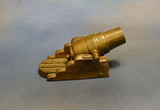 A 19th Century bronze model of a howitzer cannon, raised on a wooden trunion 5"