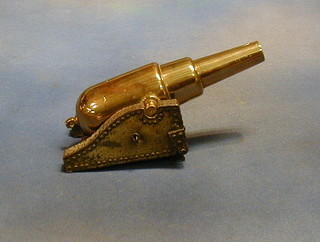 A 19th Century brass model of a howitzer cannon, raised on a wooden trunion 9"