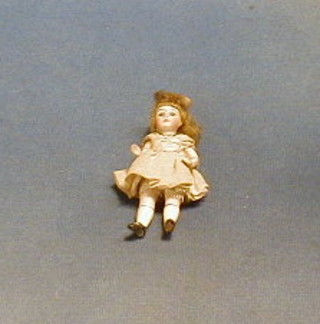 A miniature porcelain doll with articulated limbs 4"