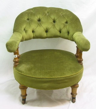 A Victorian oak framed tub back chair with bobbin turned decoration, upholstered green buttoned material, on turned supports