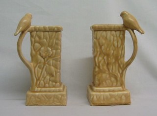 A pair of 1930's Delcroft pottery triangular shaped jars, the handles in the form of seated birds 8"