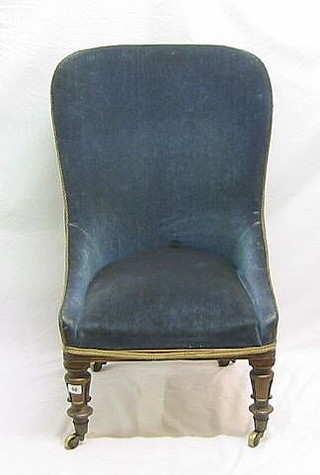 A William IV mahogany framed tub back nursing chair on turned supports with brass caps and castors