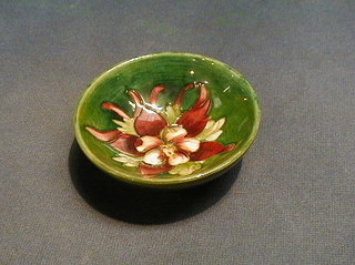 A Moorcroft green glazed Columbine pattern dish, the base with paper label by Appointment to Queen Mary, 3 1/2"