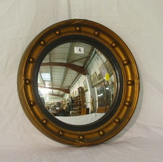 A convex plate wall mirror contained in a ball studded frame 17"