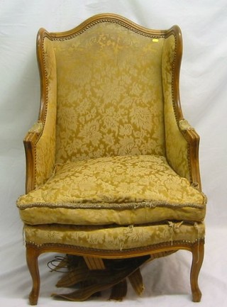 A pair of French walnutwood show frame winged armchairs upholstered in yellow material on French cabriole supports