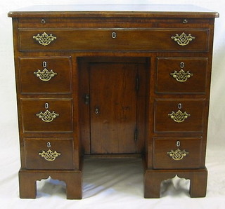 An 18th Century mahogany dressing table/desk, fitted a frieze drawer, with cupboard to the centre flanked by 6 drawers, raised on bracket feet 31"