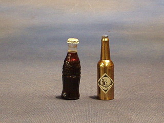 A miniature black and white bottle opener in the form of a bottle and a lighter in the form of a Coca Cola bottle