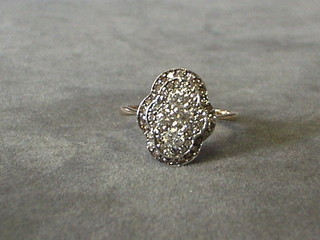 A lady's oval shaped gold dress ring set 4 diamonds surrounded by numerous diamonds (approx. 0.70ct)