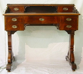 A 19th Century Continental mahogany writing table, the raised back with bobbin turned three-quarter gallery, fitted 2 drawers above 1 long and 4 short drawers, raised on standard end supports 39"