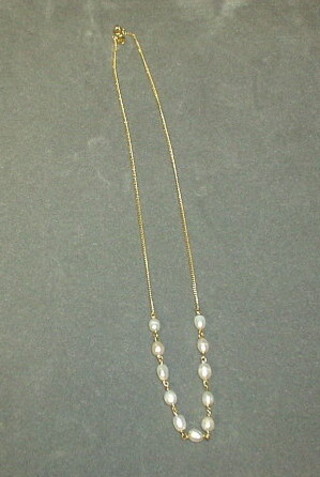 A gold chain hung seed pearls