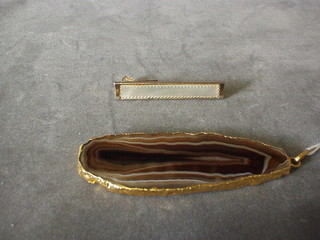 An agate pendant contained in a "gold" mount and a tie clip