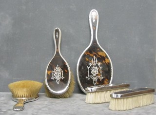 A silver and tortoiseshell 5 piece dressing table set comprising: hand mirror, 2 hair brushes and 2 clothes brushes, London 1918