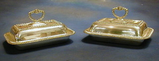 A pair of rectangular silver plated entree dishes and covers