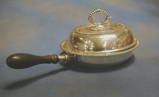 A circular silver plated entree dish and cover with turned ebony handle